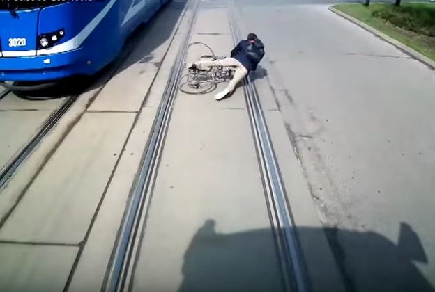 Cyklista předjíždí tramvaj a padá